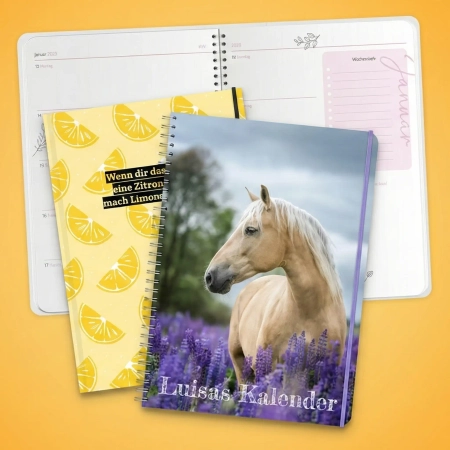 Drei personalisierte Buchkalender mit Spiral- und Buchbindung: Ein geöffneter Planer mit Wochenansicht im Hintergrund, davor zwei Cover-Designs mit Zitronen-Muster und einem Pferde-Foto.