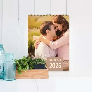 Kalender der an einer Wand hängt, davor stehen Accessoires auf einem Tisch