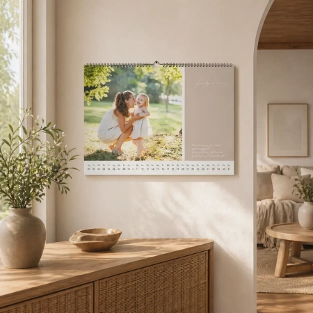 Monatskalender mit Familienfoto in einer hellen wohnlichen Szene, dekorativ an der Wand präsentiert und harmonisch in das Interieur eingebunden.
